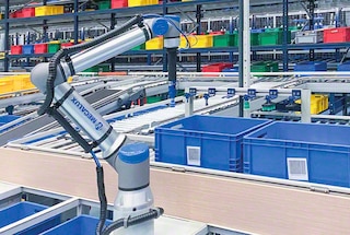 Sandėliavimo ir užsakymų dėžės atkeliauja į stotelę, kurioje veikia „paėmimo ir padėjimo“ robotas